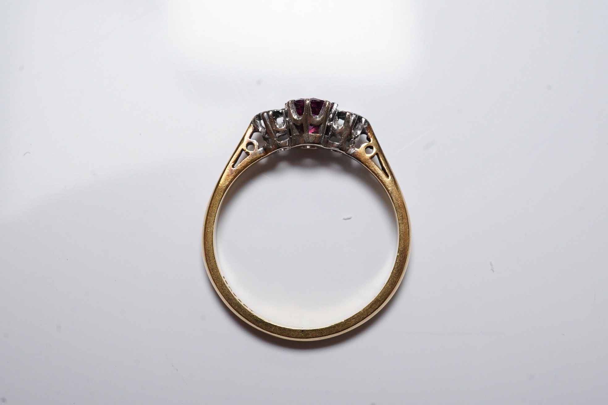 An 18ct and platinum ruby and diamond set three stone ring, size O, gross weight 3.1 grams. Condition - fair